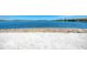 Beach view with clear water, a sandy shore, and homes in the background at 121 Porta Vecchio Bnd # 201, Nokomis, FL 34275