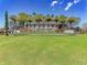 Toscana Isles community entrance with lush landscaping, flowers and a stone monument sign at 121 Porta Vecchio Bnd # 201, Nokomis, FL 34275