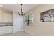 Dining room with white cabinets, granite countertops, chandelier, and a large window with blinds at 121 Porta Vecchio Bnd # 201, Nokomis, FL 34275