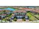 A beautifully landscaped two-story home featuring a brick driveway, lush palm trees, and stunning lake views at 121 Porta Vecchio Bnd # 201, Nokomis, FL 34275