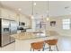 Well-lit kitchen with stainless steel appliances, white cabinetry, and a spacious island with bar seating at 121 Porta Vecchio Bnd # 201, Nokomis, FL 34275