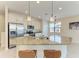 Modern kitchen with stainless steel appliances, granite countertops, and an island with seating at 121 Porta Vecchio Bnd # 201, Nokomis, FL 34275