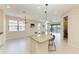 Bright kitchen featuring a large island with granite countertops, pendant lighting, and an adjacent view of the water at 121 Porta Vecchio Bnd # 201, Nokomis, FL 34275