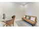 Comfortable office space featuring a futon, rug, glass desk, and wicker chair at 121 Porta Vecchio Bnd # 201, Nokomis, FL 34275