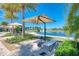 Beautiful lake view with lounge chairs and umbrellas for relaxing outdoors near the pool at 121 Porta Vecchio Bnd # 201, Nokomis, FL 34275