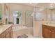 Bathroom featuring double sinks, garden tub, a separate shower and a large window at 12358 Lavender Loop, Bradenton, FL 34212