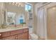 Well-lit bathroom with wood vanity, stylish mirror, and shower with curtain at 12358 Lavender Loop, Bradenton, FL 34212