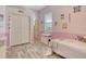 Bright bedroom featuring pink walls, wood-look floors and built-in closet space at 12358 Lavender Loop, Bradenton, FL 34212