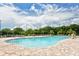 Spacious community pool with lounge chairs, trees, and clear blue water under a sunny sky at 12358 Lavender Loop, Bradenton, FL 34212