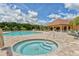 Community pool and hot tub area with lounge chairs, umbrellas, and a clubhouse view at 12358 Lavender Loop, Bradenton, FL 34212