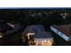 Night exterior view of a well-lit home showcasing a 3-car garage and arched entry at 12358 Lavender Loop, Bradenton, FL 34212