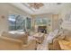 Comfortable living room with hardwood floors, a ceiling fan, ample natural light, and views of the screened-in pool area at 12358 Lavender Loop, Bradenton, FL 34212