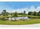 Scenic community pond surrounded by lush landscaping and palm trees on a sunny day at 12358 Lavender Loop, Bradenton, FL 34212