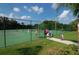 Community tennis court with players and Gathering enjoying a match on a sunny day at 12358 Lavender Loop, Bradenton, FL 34212