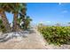 Community beach access and gate with lush greenery and beach views at 1255 E Peppertree Dr # 507, Sarasota, FL 34242