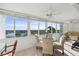 Sunroom dining area showcases glass table and chair set, perfect for enjoying water views at 1255 E Peppertree Dr # 507, Sarasota, FL 34242