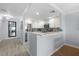 Bright kitchen with white cabinets, stainless appliances, and a breakfast bar opening to the living room at 1255 E Peppertree Dr # 507, Sarasota, FL 34242