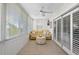Bright sunroom featuring light wood flooring, a ceiling fan, and a comfortable yellow sofa and ottoman set at 1255 E Peppertree Dr # 507, Sarasota, FL 34242