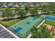 Aerial view of basketball and tennis courts and a playground surrounded by well-maintained community grounds at 12644 20Th E St, Parrish, FL 34219