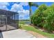 Backyard view showcasing the screened-in porch and lush landscaping with a view of the lake at 12644 20Th E St, Parrish, FL 34219