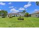 Expansive green backyard showcases meticulous landscaping, with a partial view of the pool and the house at 12644 20Th E St, Parrish, FL 34219