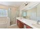 Primary bathroom featuring double sinks, walk-in shower with seating, and a soaking tub with glass block window at 12644 20Th E St, Parrish, FL 34219