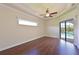 Bright bedroom boasts hardwood floors, tray ceiling with fan, and sliding glass doors to pool at 12644 20Th E St, Parrish, FL 34219
