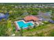 Aerial view of a pool surrounded by palm trees, lounge chairs and green landscaping in a well-maintained community at 12644 20Th E St, Parrish, FL 34219