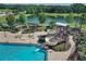 Aerial view showcasing community pool with water slide, play area, and lake, providing a variety of recreational opportunities at 12755 Rainwashed Loop, Parrish, FL 34219
