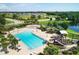 Aerial view of community amenities including a large pool, splash pad, playground, and scenic surroundings at 12755 Rainwashed Loop, Parrish, FL 34219