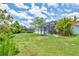 Expansive backyard featuring a screened-in patio and mature trees at 12755 Rainwashed Loop, Parrish, FL 34219