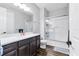 Bathroom with wood look tile flooring, a shower-tub combo, and vanity with dark wood cabinetry at 12755 Rainwashed Loop, Parrish, FL 34219