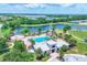 Aerial view showcasing the community pool and splashpad, alongside a scenic lake and surrounding residential area at 12755 Rainwashed Loop, Parrish, FL 34219
