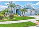 Charming single-Gathering home featuring a two-car garage and a well-maintained lawn with decorative landscaping and palm trees at 12755 Rainwashed Loop, Parrish, FL 34219