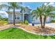 Charming home with stone accents, lush landscaping, a well-manicured lawn, and mature palm trees in the front yard at 12755 Rainwashed Loop, Parrish, FL 34219