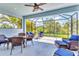 Screened-in lanai providing outdoor seating with views of the greenery, complete with comfortable wicker furniture and a ceiling fan at 12755 Rainwashed Loop, Parrish, FL 34219