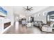 Open living room with tile flooring, contemporary furniture, fireplace, and views into the kitchen and dining areas at 12755 Rainwashed Loop, Parrish, FL 34219