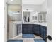 Main bathroom with dual sinks, granite countertops, blue cabinets, and a glass enclosed shower at 12755 Rainwashed Loop, Parrish, FL 34219