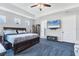 Carpeted main bedroom features tray ceiling, ceiling fan, and television above a storage unit at 12755 Rainwashed Loop, Parrish, FL 34219