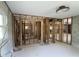Spacious, partially renovated interior space featuring exposed framing, concrete walls, and natural light from the window at 129 Pierson Ln, Sarasota, FL 34242