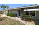 Charming home entrance with manicured bushes, rock accents, and a stylish awning at 135 Gulfview Rd, Punta Gorda, FL 33950