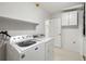 Bright laundry area with modern washer and dryer, white walls, and overhead cabinet at 135 Gulfview Rd, Punta Gorda, FL 33950