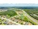 Aerial view of homes in a lush community, near a highway and lake at 13819 American Prairie Pl, Bradenton, FL 34211