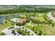 Stunning aerial view of a community clubhouse, pool, and recreation area surrounded by lush landscaping and a tranquil lake at 13819 American Prairie Pl, Bradenton, FL 34211