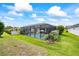 Backyard view of the screened-in pool, with grass and landscaping at 13819 American Prairie Pl, Bradenton, FL 34211