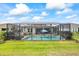 Expansive backyard view of the private pool area with covered outdoor kitchen and lush landscaping at 13819 American Prairie Pl, Bradenton, FL 34211