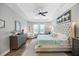 Bright bedroom featuring tray ceilings, a ceiling fan, and natural light from large windows at 13819 American Prairie Pl, Bradenton, FL 34211
