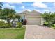 Charming single-Gathering home features a manicured lawn, brick driveway, and attached two-car garage at 13819 American Prairie Pl, Bradenton, FL 34211