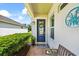 Cozy front porch features brick pavers, a blue door with wreath, and bench seating at 13819 American Prairie Pl, Bradenton, FL 34211