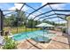 Screened pool with beach entry, sun shelf, umbrella, and backyard views at 13819 American Prairie Pl, Bradenton, FL 34211